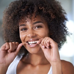 woman smiling while flossing