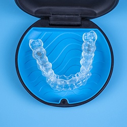 An Invisalign aligner sitting inside a protective case
