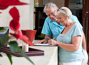 Older couple signing in at front desk