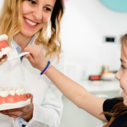 dentist showing child brushing techniques